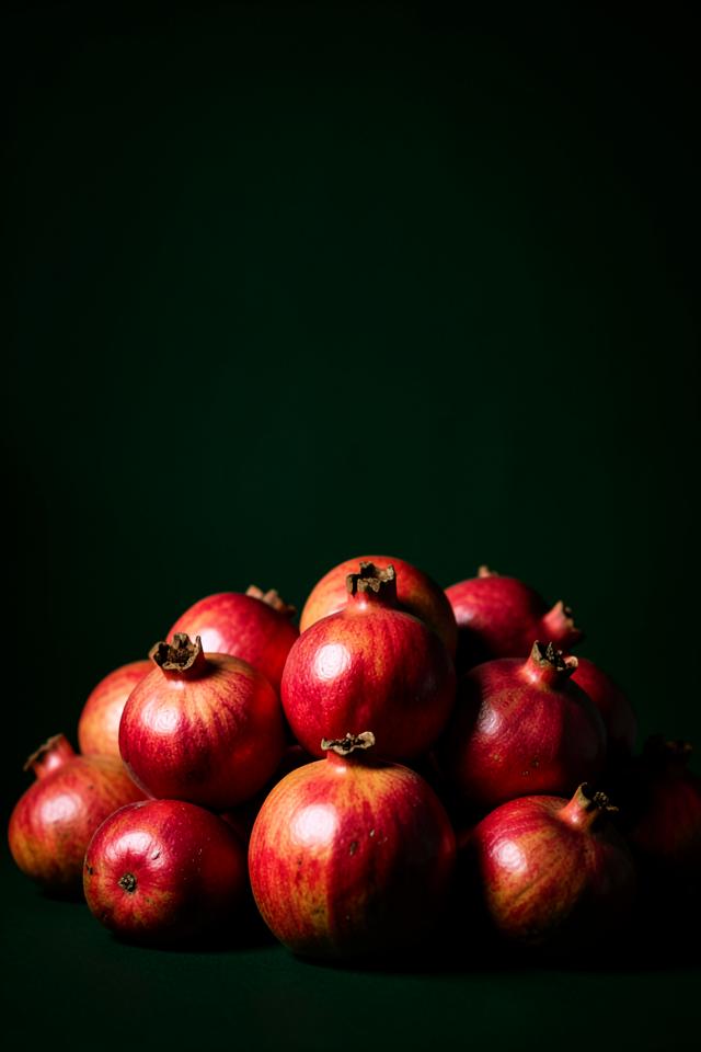 Whole and halved pomegranates showing deep red arils