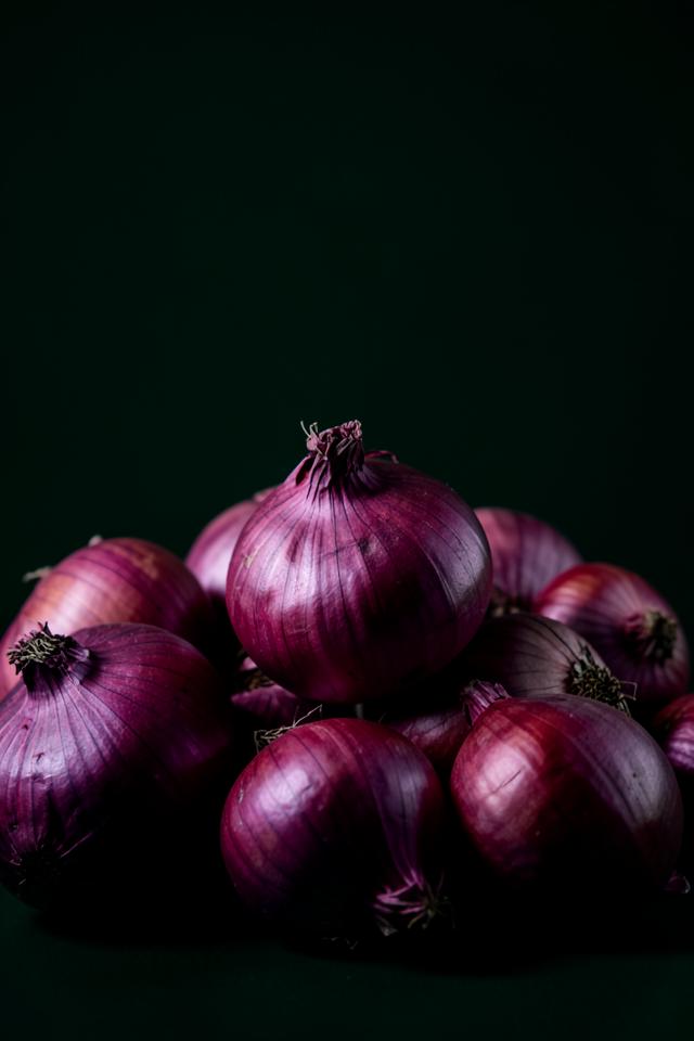 Pile of glossy red onions with deep purple skins